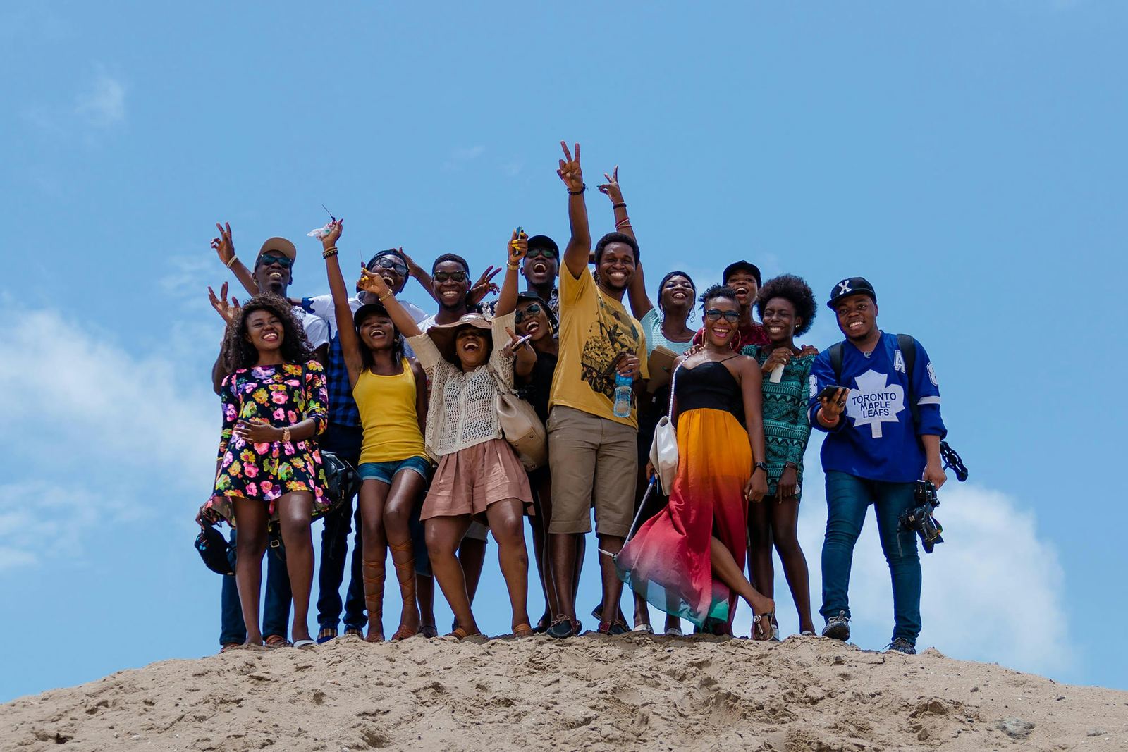Group of cheerful young professionals celebrating together on a sand dune