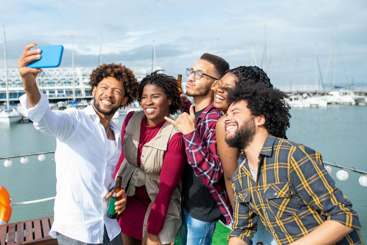 Friends taking a selfie on a boat in a harbour