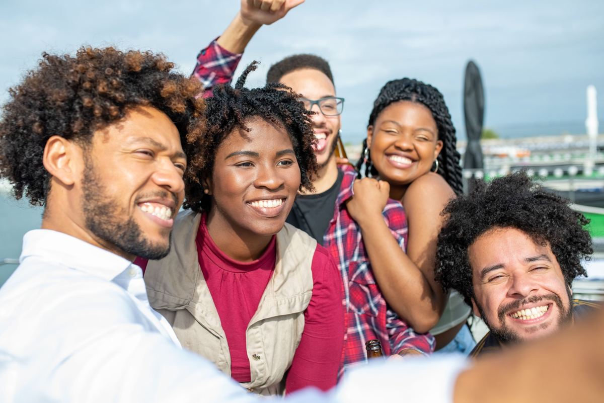 Group of friends laughing together by the sea